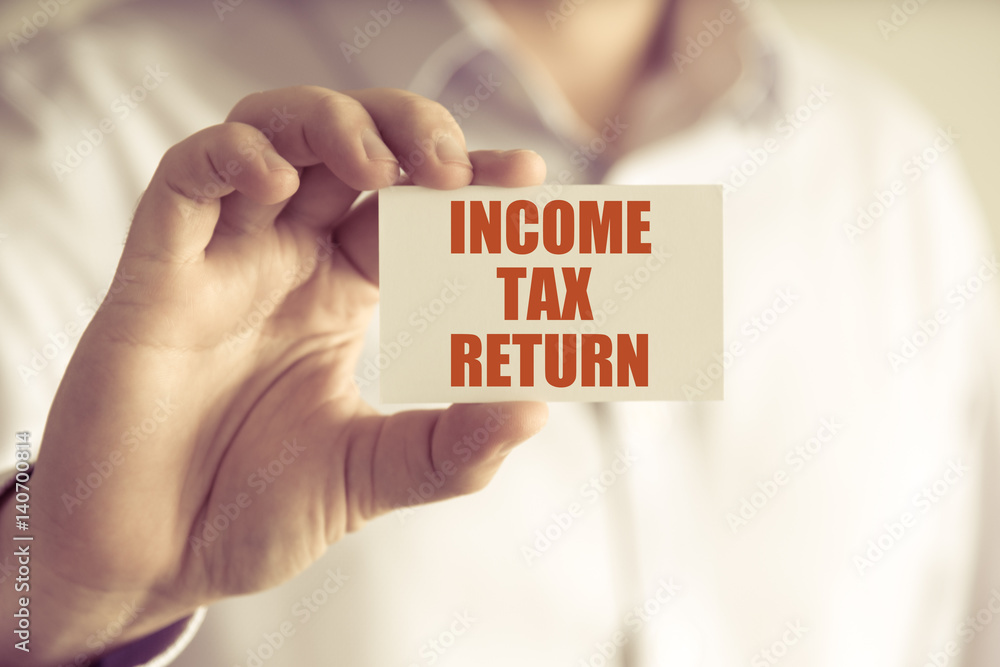 Businessman holding INCOME TAX RETURN message card