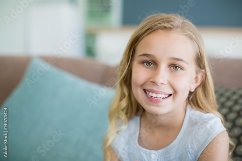 Free Download Portrait of a happy girl relaxing on sofa - GFXLoad