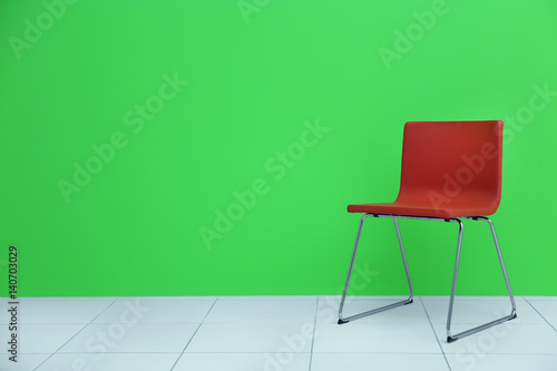 Red modern chair on green wall background