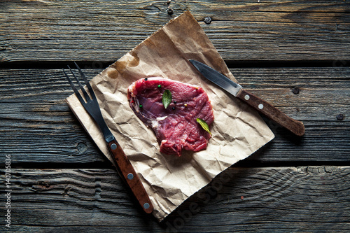 Pieces of meat, steak with spices on a wooden background. Food