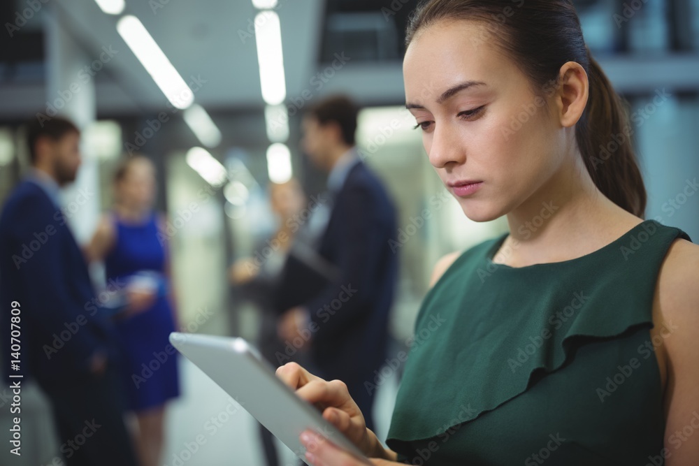 Female executive using digital tablet in corridor Female executive using digital tablet in corridor