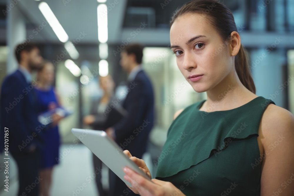 Female executive using digital tablet in corridor Female executive using digital tablet in corridor