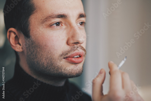 Man is thinking while smoking cigarette photo