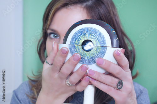 Ophthalmology oculus sample closeup. Ophthalmology, eye model close-up. The girl is holding a model of the eye. photo