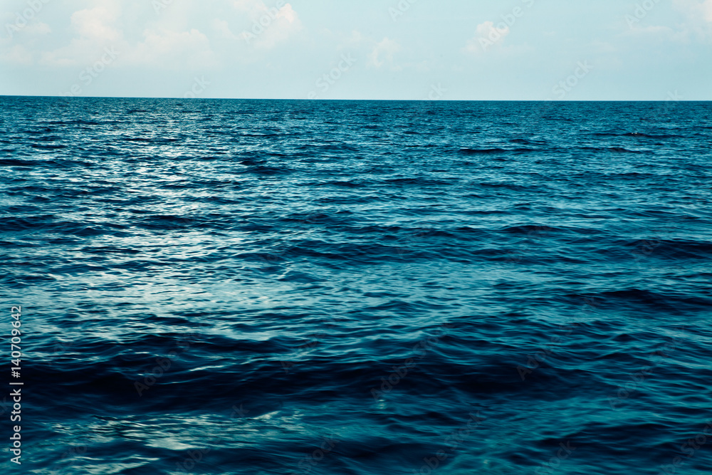Fototapeta premium summer sea with blue water wave. Outdoor tropical summer sea paradise. Heaven view of deep transparent ocean. Sunshine reflection on a calm summer ocean. Tranquility of turquoise water