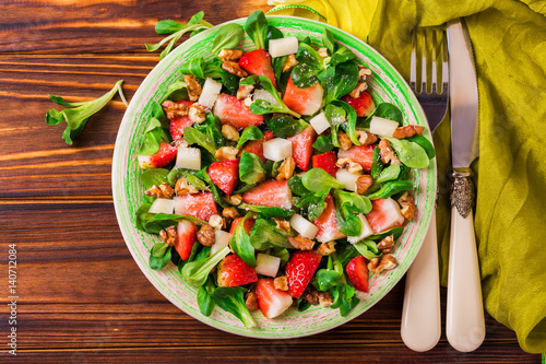 Salad with strawberry, spinach, walnuts and goat cheese