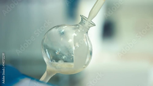 Milk analysis. Analysis of milk sample on laboratory equipment. Modern equipment. Scientist put glass with milk in laboratory equipment for research. Food quality test