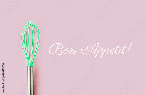 Fotografie Neon green culinary whisk top view on colorful background