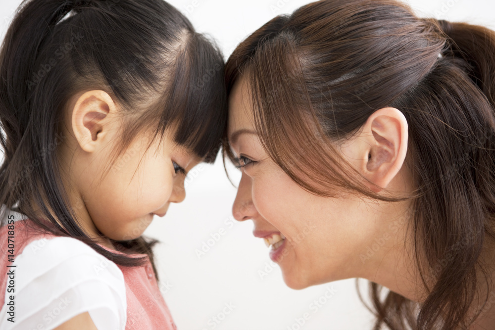 Mother and daughter touching forehead Mother and daughter touching forehead