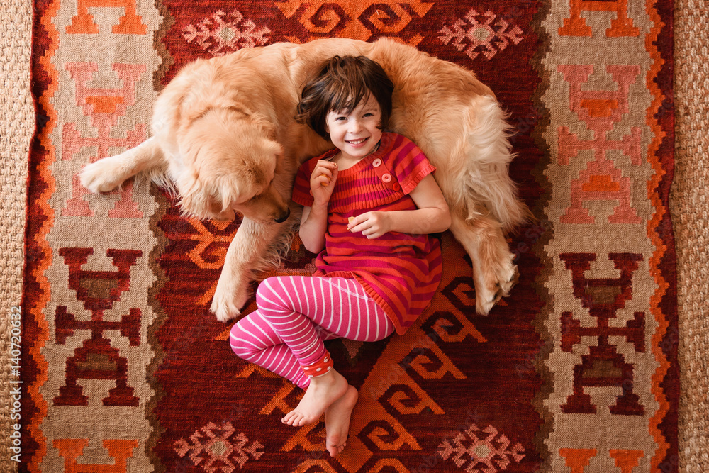 Overhead view of girl lying on floor with a golden retriever dog Stock ...