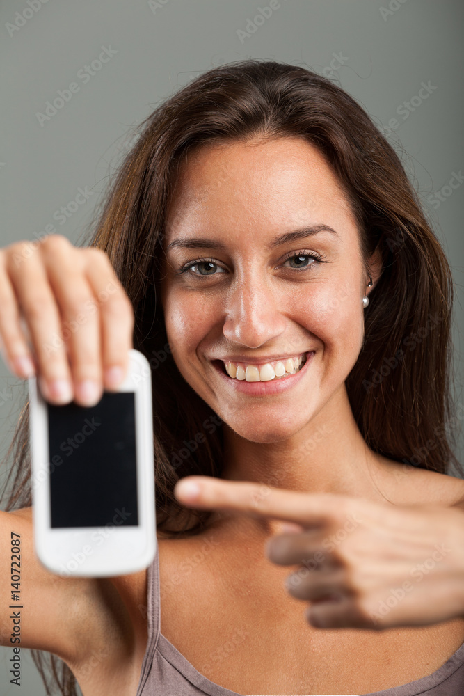 Happy attractive woman pointing to her mobile Happy attractive woman pointing to her mobile