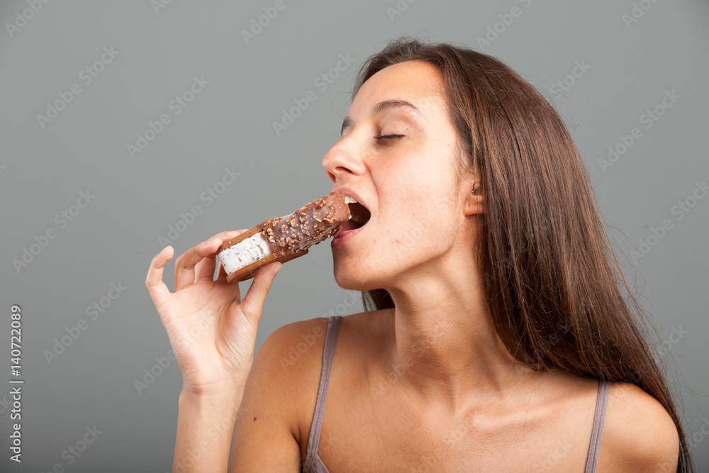 Sensual young woman biting into an ice cream bar Sensual young woman biting into an ice cream bar