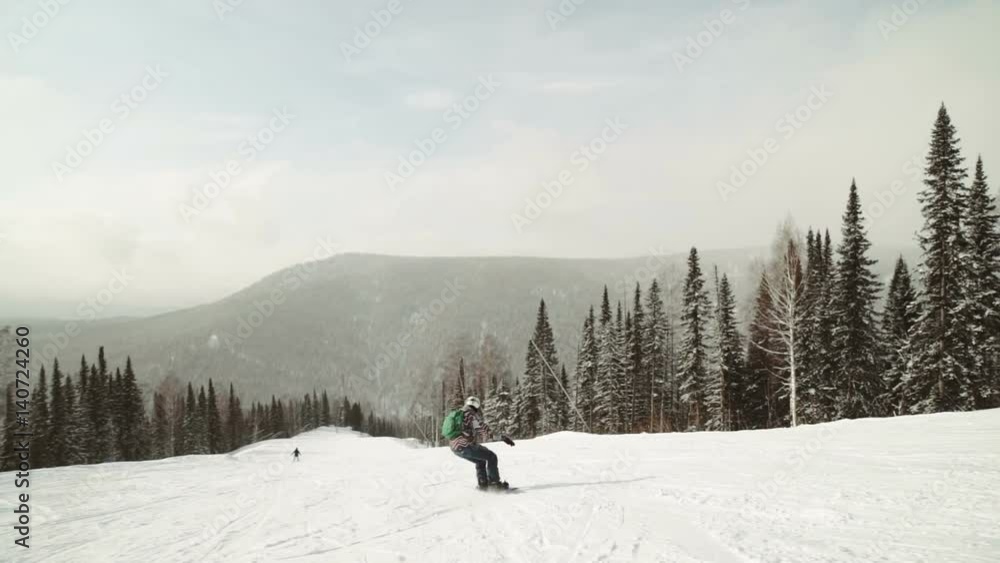 Young female snowboarder riding fresh powder snow in beautiful snowy mountain in sunny winter. perfect powder snow off piste in mountain ski resort. Young female snowboarder riding fresh powder snow in beautiful snowy mountain in sunny winter. perfect powder snow off piste in mountain ski resort.