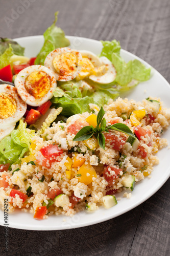 Deviled egg salad with side of tabbouleh salad with couscous, tomatoes, onion, zucchini and bell peppers vertical shot