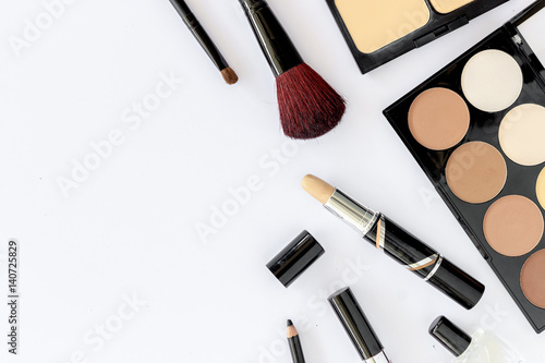 makeup cosmetics on white table background, over light, top view