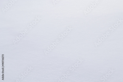 The snow nast. Texture, background. Smooth snow surface. Light shadows lie on the snow.