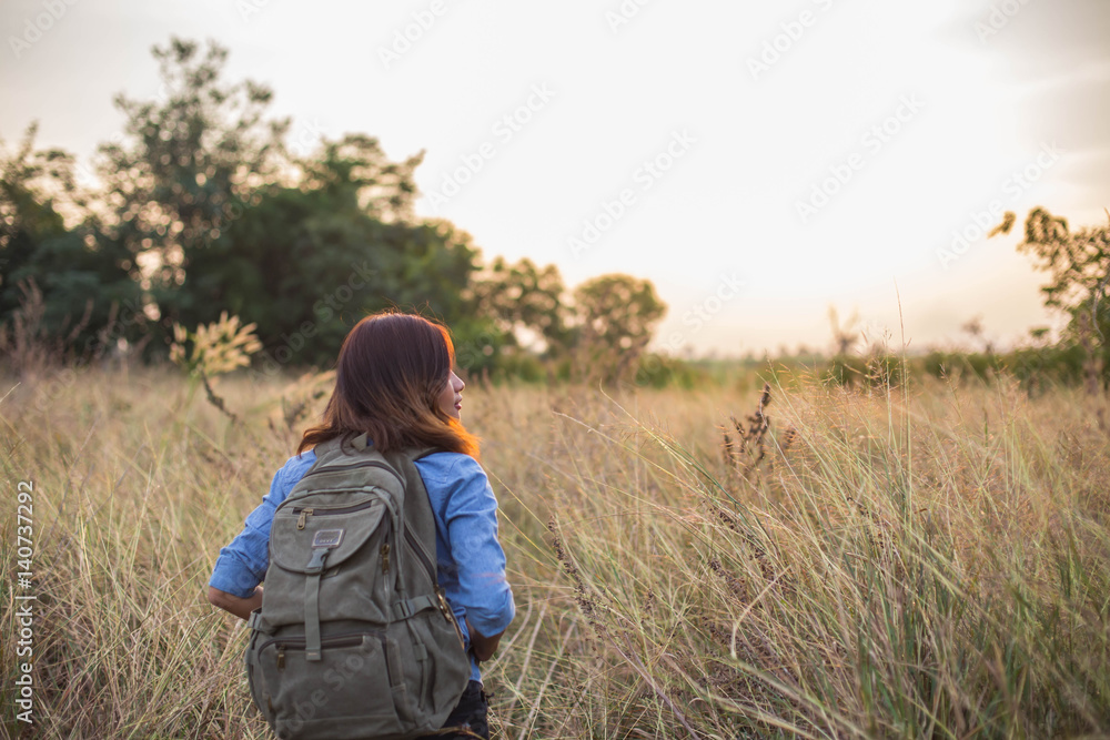 Woman carrying bag of travelers in the field sunsets