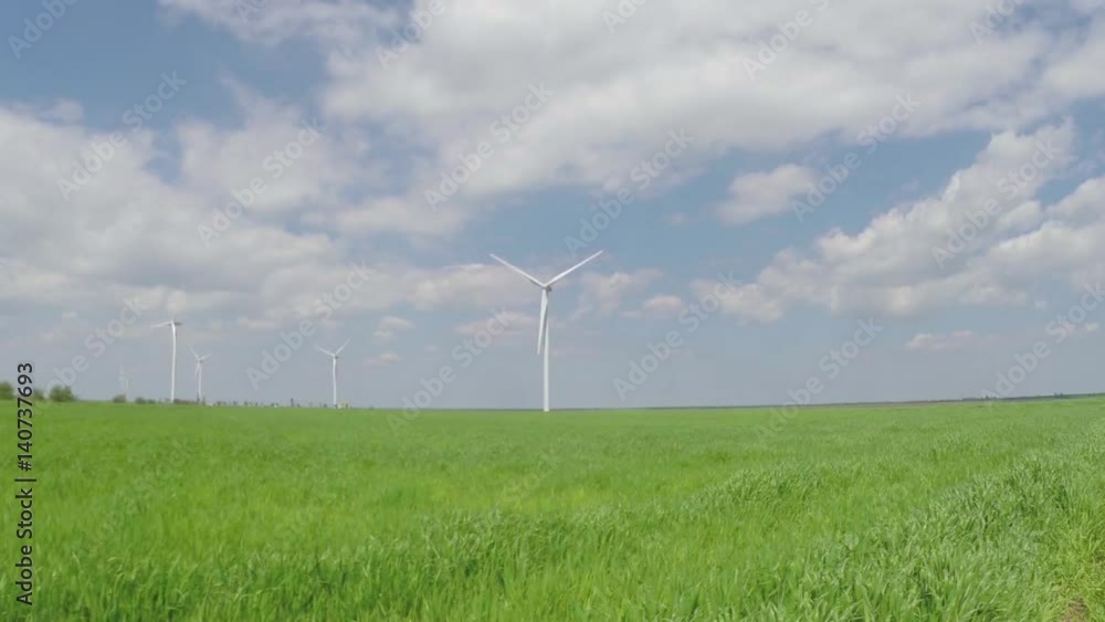 Green field with blue sky and clouds with working wind turbines Green field with blue sky and clouds with working wind turbines