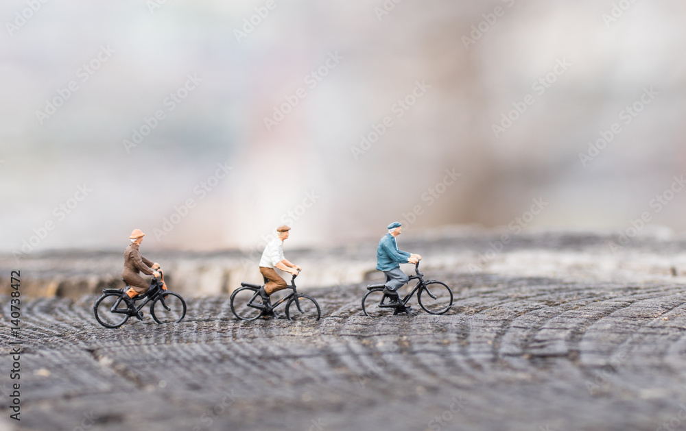 Miniaturradfahrer auf einem Baumstamm