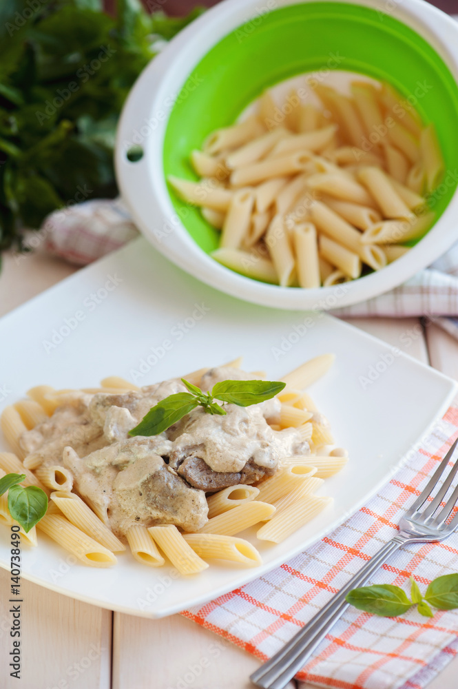 Penne pasta with meat and white sauce on a plate Penne pasta with meat and white sauce on a plate