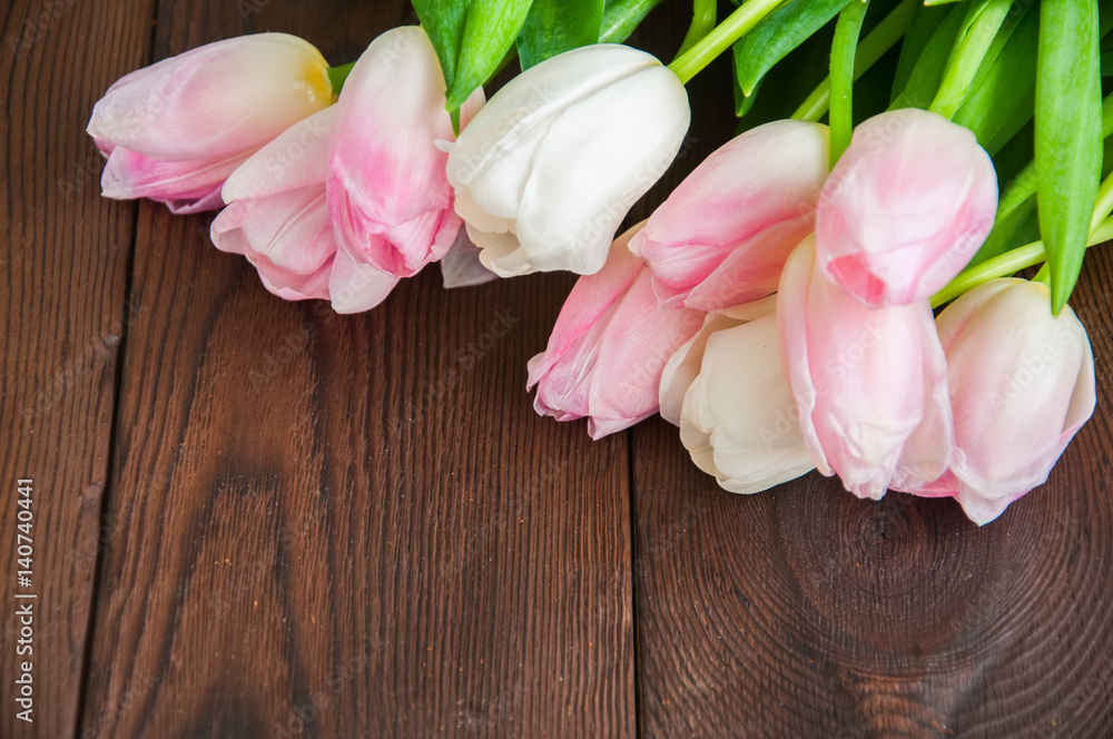 Rose-colored tulips on a wooden background. Copy Space and close up.