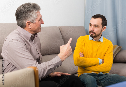 Fotografija Adult father and son solve problems
