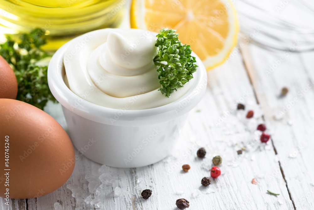 Mayonnaise sauce and ingredients on white