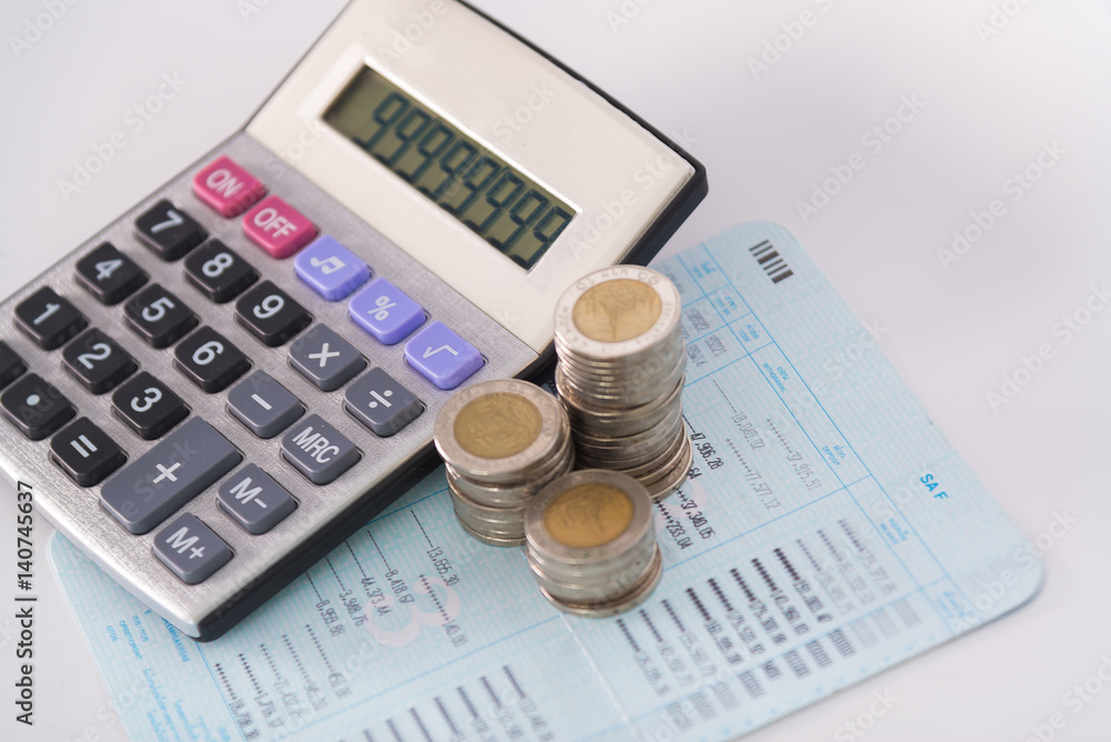Increasing columns of coins, piles of coins arranged as a graph and calculator on white background Increasing columns of coins, piles of coins arranged as a graph and calculator on white background