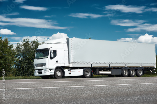 White truck on road with blue sky, cargo transportation concept © soleg