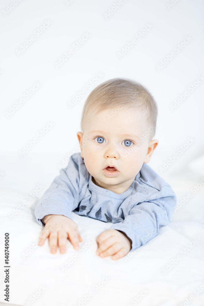 beautiful baby boy lying in bed on white background beautiful baby boy lying in bed on white background