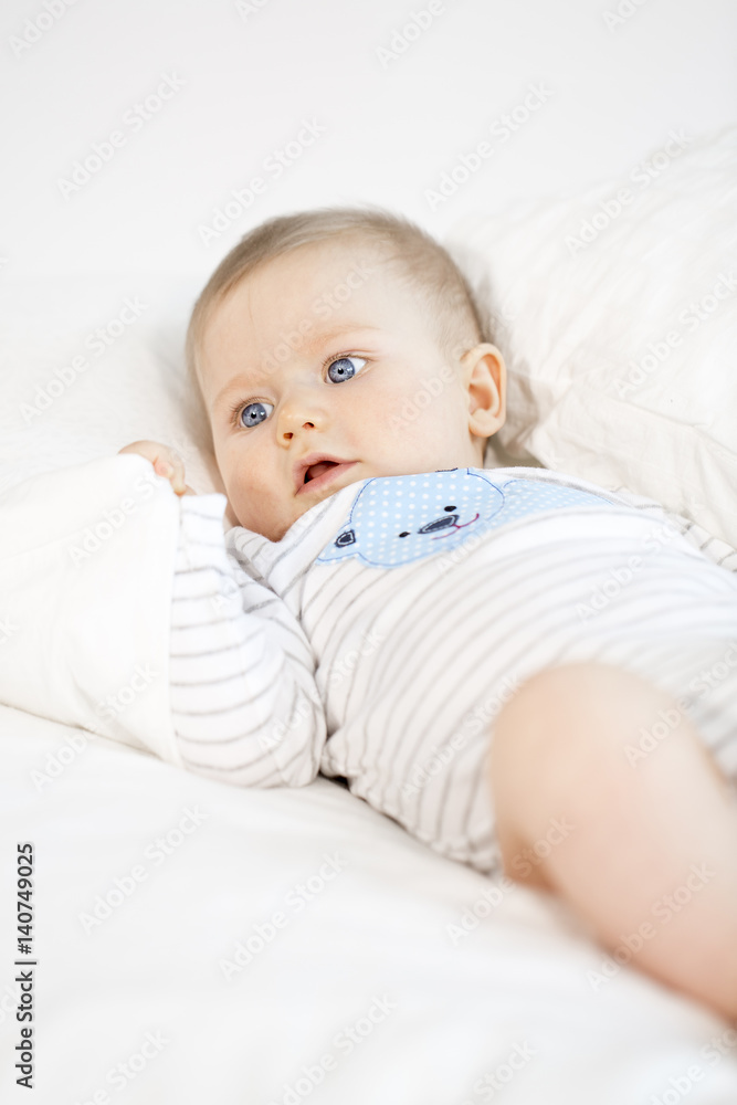 beautiful baby boy lying in bed on white background beautiful baby boy lying in bed on white background