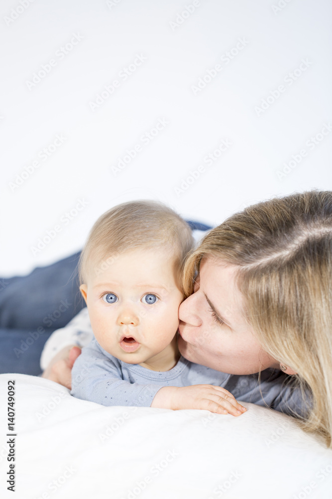beautiful mother and baby boy lying in bed in child room beautiful mother and baby boy lying in bed in child room