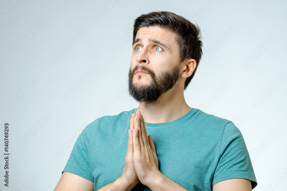 Hopeful young man praying isolated Hopeful young man praying isolated
