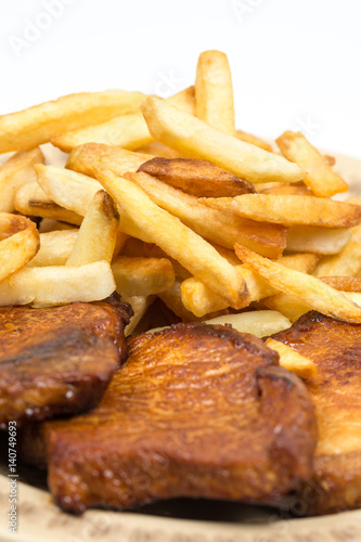 Stewed pork chops with french fries on the plate