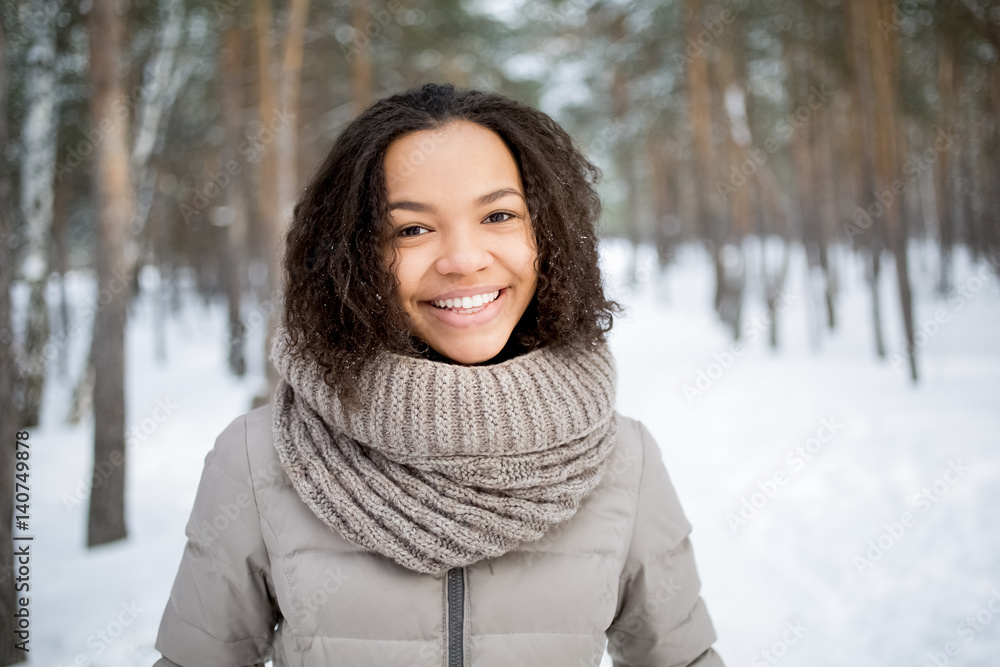 Cheerful African woman smiling at camera in winter Cheerful African woman smiling at camera in winter