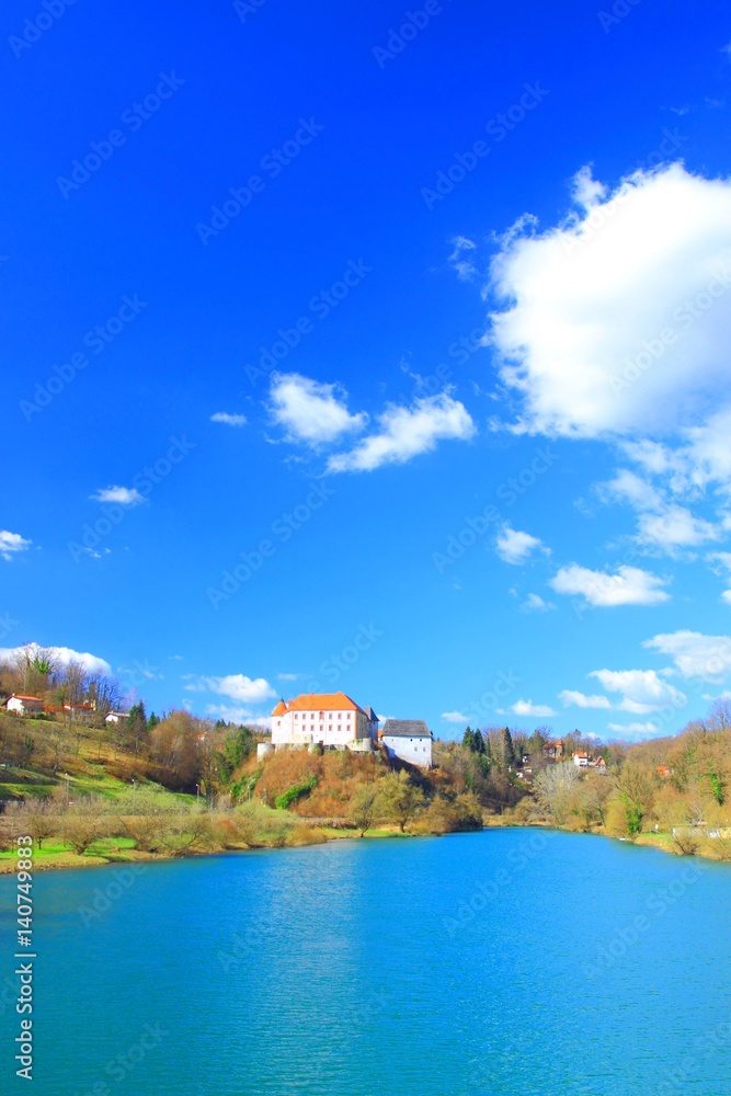 River Kupa and Castle on hill, Ozalj in Croatia, blue sky with clouds in background