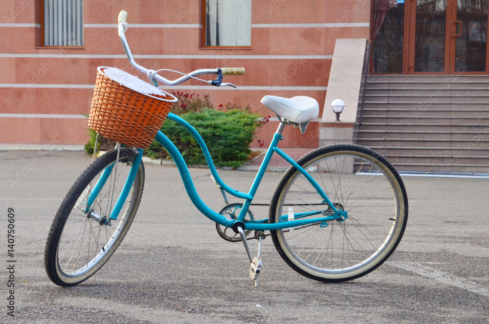 Retro blue women's bicycle with basket in front outdoor Retro blue women's bicycle with basket in front outdoor