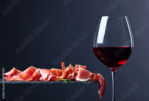 prosciutto with rosemary and red wine on a black  background photo