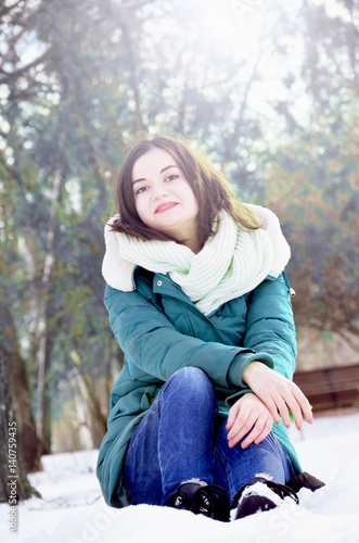 Beautiful young woman in the park in sunny winter day.