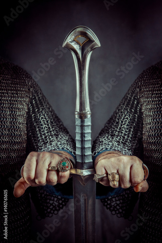 Photography Two powerful knights are holding the hilt of one sword.