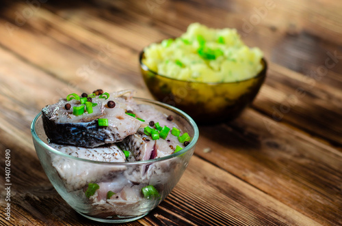 Mashed potatoes and marinated carp on wooden table