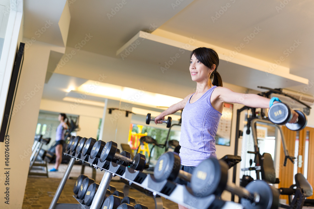 Woman doing exercises with dumbbells in the gym Woman doing exercises with dumbbells in the gym