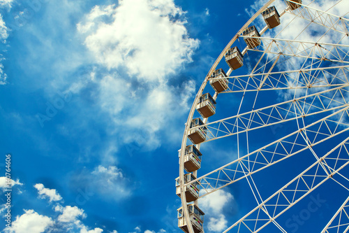 Ferris wheel on the blue sky background. Summer entertainment