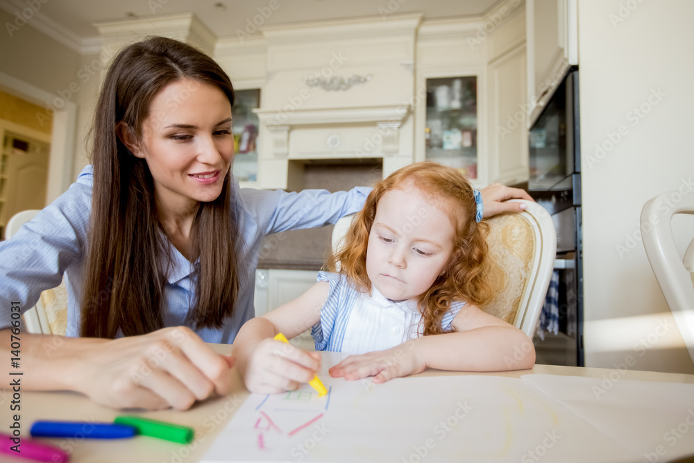 Happy mother or nanny looking at drawing girl Happy mother or nanny looking at drawing girl