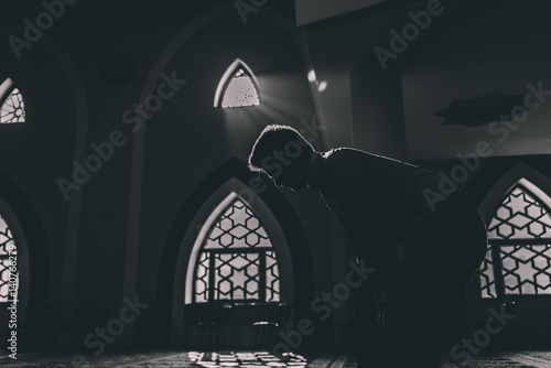Humble Muslim praying in silence with cool background