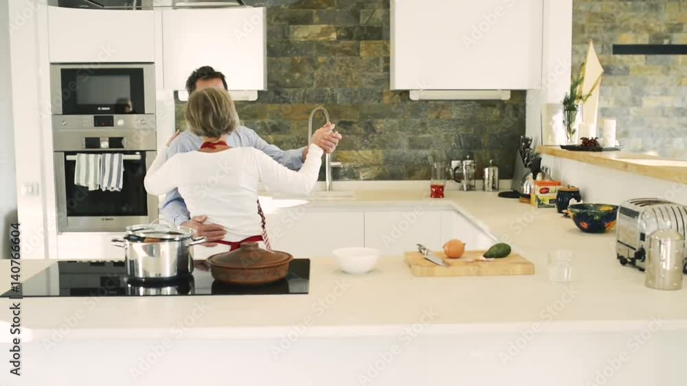 Senior couple in the kitchen cooking and dancing together. Senior couple in the kitchen cooking and dancing together.