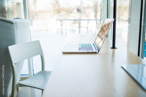 Close-up of comfortable working place in office with wooden table with laptop