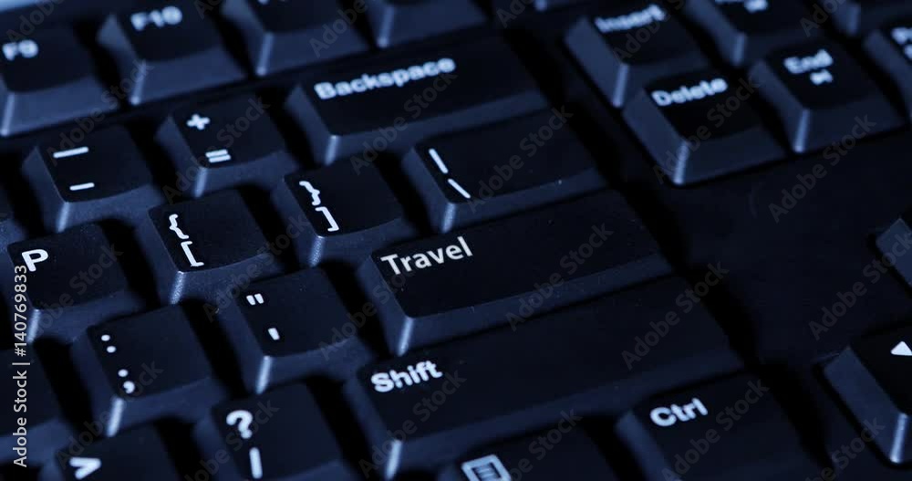 Close up of human finger pressing a Travel button on the computer keyboard Close up of human finger pressing a Travel button on the computer keyboard