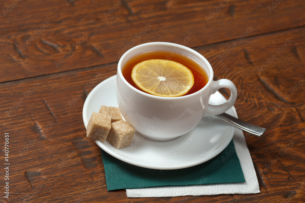 Obraz premium Cup of tea with lemon on a wooden table