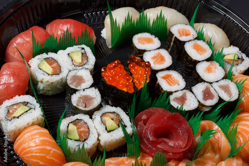 A large set of sushi and rolls view from above. A lot of food in one plate. Dishes from raw fish Japanese food.A dish in a romantic style. I love you. Heart with red fish caviar